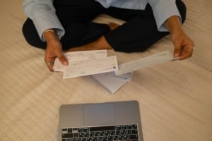 Homeowner reviewing financial documents for residential real estate investment on a laptop, showcasing a proactive lifestyle.