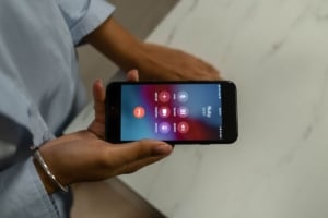 Hand holding a smartphone for real estate consultations, enhancing client connectivity in Portland real estate transactions.