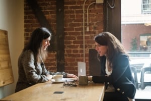 two women talking in a coffee shop