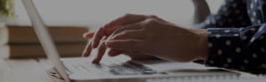 hands typing on laptop researching homes for sale