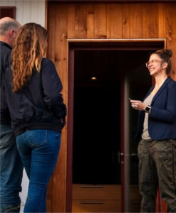 Realtor welcoming clients at front door of modern Portland home