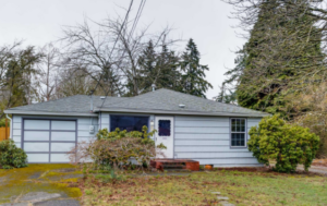Single level Portland home with attached garage and mature trees in front yard