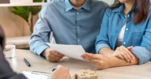 Couple reviewing real estate contract with agent for home buying or selling decisions
