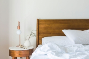 Updated and clean bedroom with mussed up sheets.