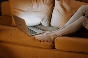 Warm and cozy couch with pillows and a computer to be comfortable at home.