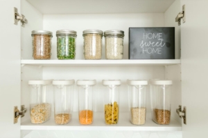 Cleaned and organized kitchen showing jars of pasta and beans on a clean shelf with sign saying Home Sweet Home.