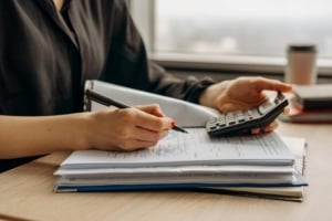 Real estate professional calculating figures for property investments and home financing, emphasizing investment readiness.