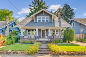 Charming Craftsman-style single-family home with landscaped gardens and inviting porch, ideal for Portland real estate seekers.