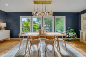 Bright dining area featuring a modern chandelier, large windows, and a stylish open-concept design ideal for Portland homes.