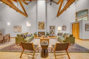 Spacious open-concept living area featuring exposed beams, modern furnishings, and cozy fireplace, ideal for Portland homes.