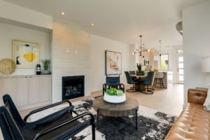 Modern open-concept living space featuring a cozy fireplace, stylish seating, and a chic dining area in a Portland residence.