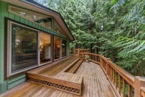 Spacious deck of a modern single-family home in a wooded setting, ideal for outdoor living in Portland real estate.