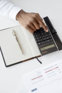 Calculator and notebook for financial planning in Portland real estate investment, focusing on home buying strategies.