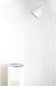 Modern white floor lamp and air purifier in a minimalist living space, reflecting clean design in residential interiors.
