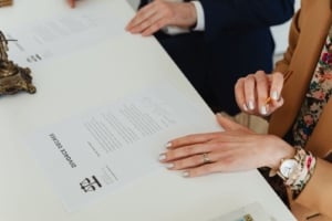 Signing legal documents related to property during a divorce, focusing on real estate investment and home ownership insights.