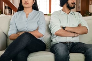 Couple discussing home buying in a modern living room, showcasing the importance of communication in real estate decisions.